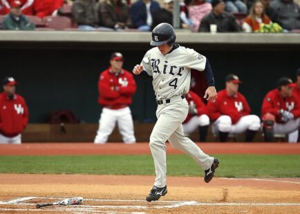 A baseball player trots triumphantly to home plate.