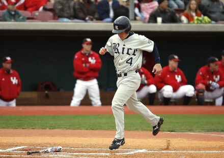 A baseball player trots triumphantly to home plate.
