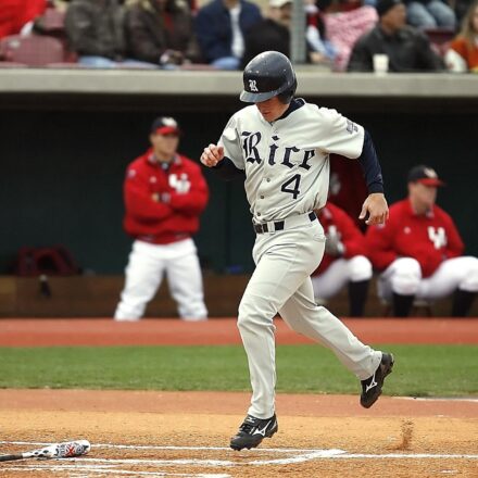 A baseball player trots triumphantly to home plate.