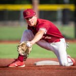 A baseball player reaches out to catch the ball with his mitt.
