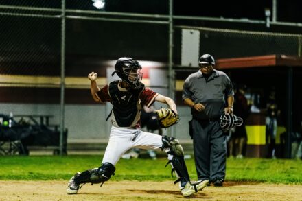 A catcher at home plate winds up to throw the ball.