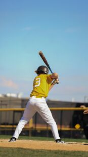 A baseball player raises his bat, ready for the pitch.