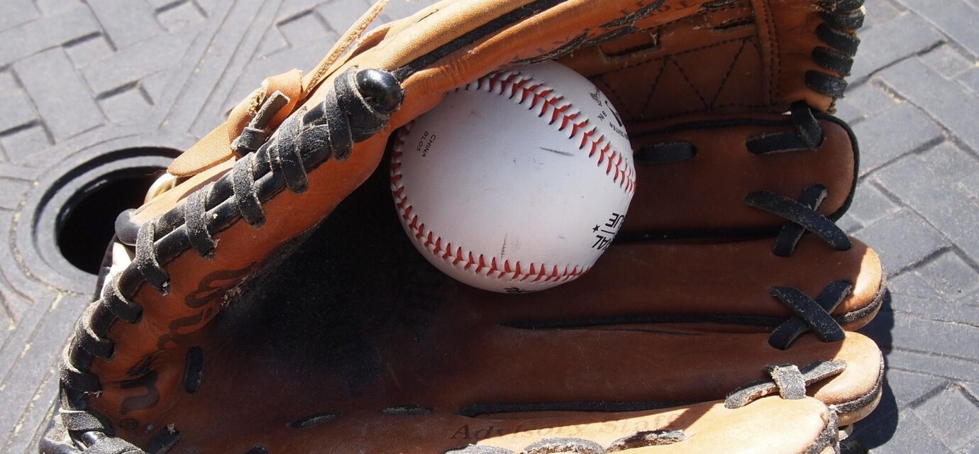 A baseball hides inside of a baseball glove.