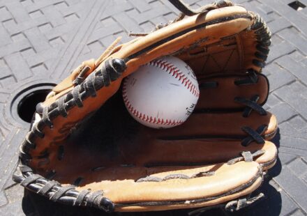 A baseball hides inside of a baseball glove.