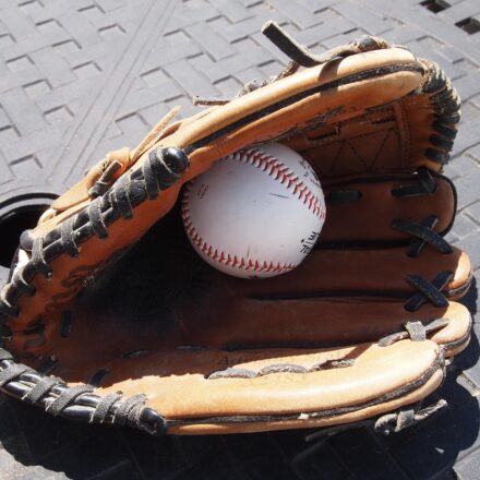 A baseball hides inside of a baseball glove.