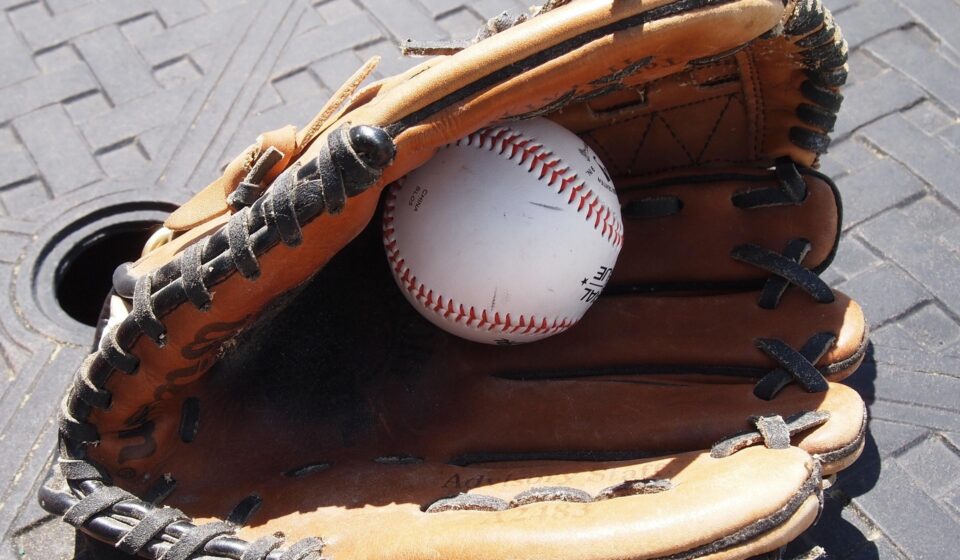 A baseball hides inside of a baseball glove.