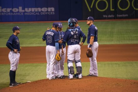 Several players gather on the pitcher's mound for a conference.