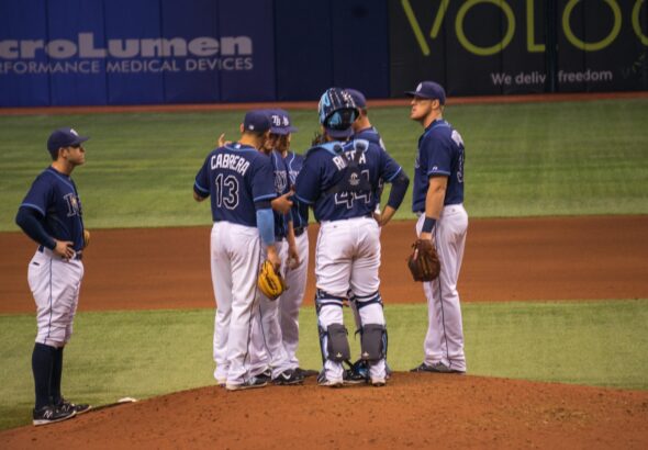 Several players gather on the pitcher's mound for a conference.