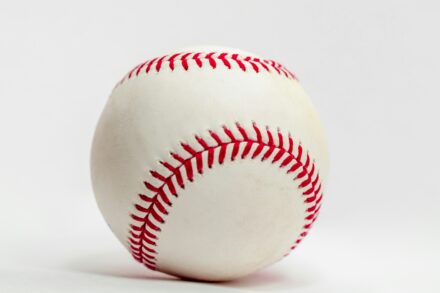 A baseball stands out against a white background.