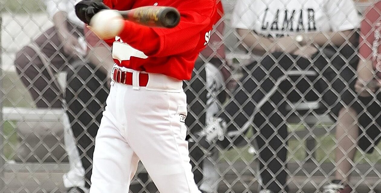 A batter at home plate swings at the ball.