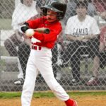 A batter at home plate swings at the ball.
