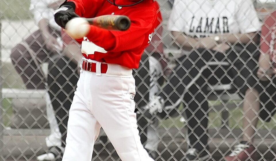A batter at home plate swings at the ball.