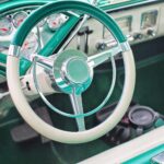 The interior of a classic vehicle in aqua and white.