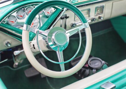 The interior of a classic vehicle in aqua and white.