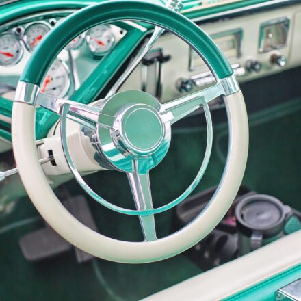 The interior of a classic vehicle in aqua and white.