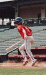A baseball player is ready to run to first base.