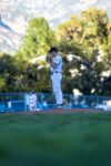 A pitcher stands on a mound in a baseball field.