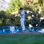A pitcher stands on a mound in a baseball field.