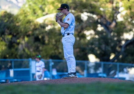 A pitcher stands on a mound in a baseball field.