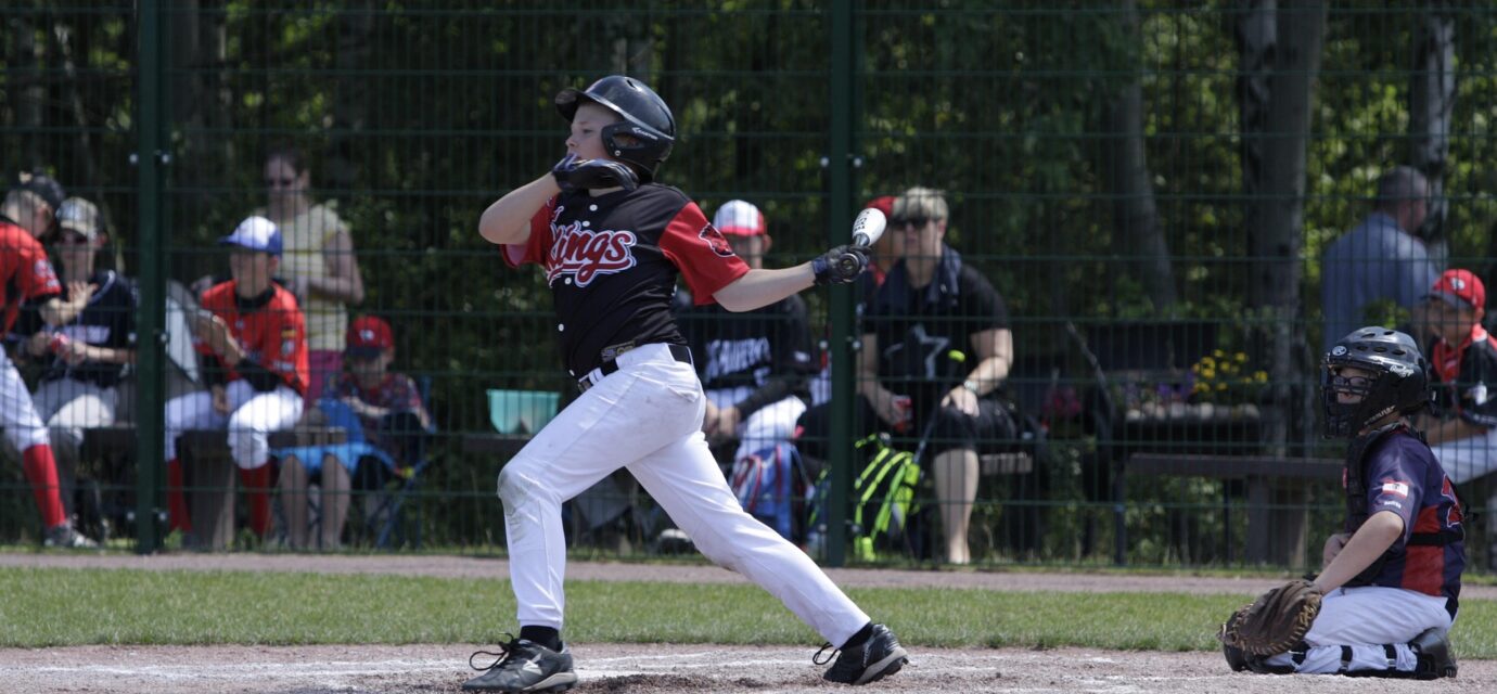 A baseball player lets fly with his bat.