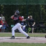 A baseball player lets fly with his bat.