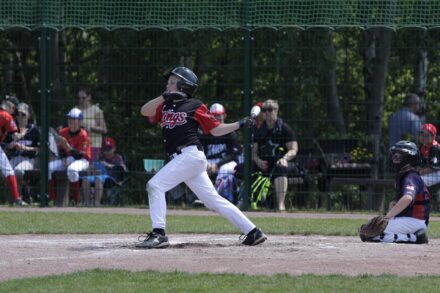 A baseball player lets fly with his bat.