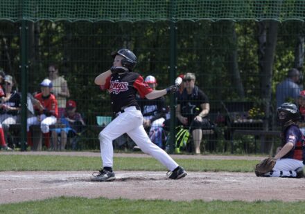A baseball player lets fly with his bat.
