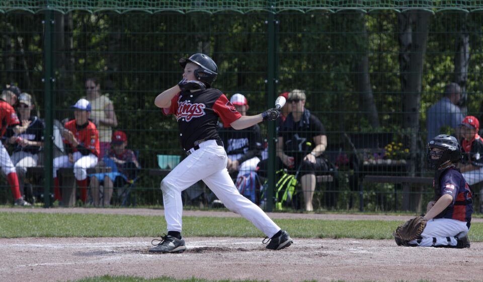A baseball player lets fly with his bat.