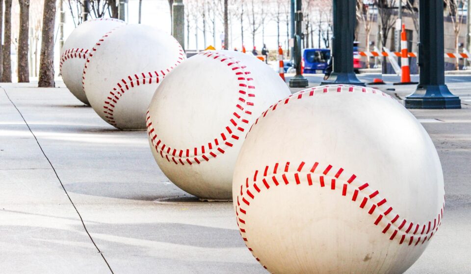 A row of oversized baseballs lines a sidewalk.