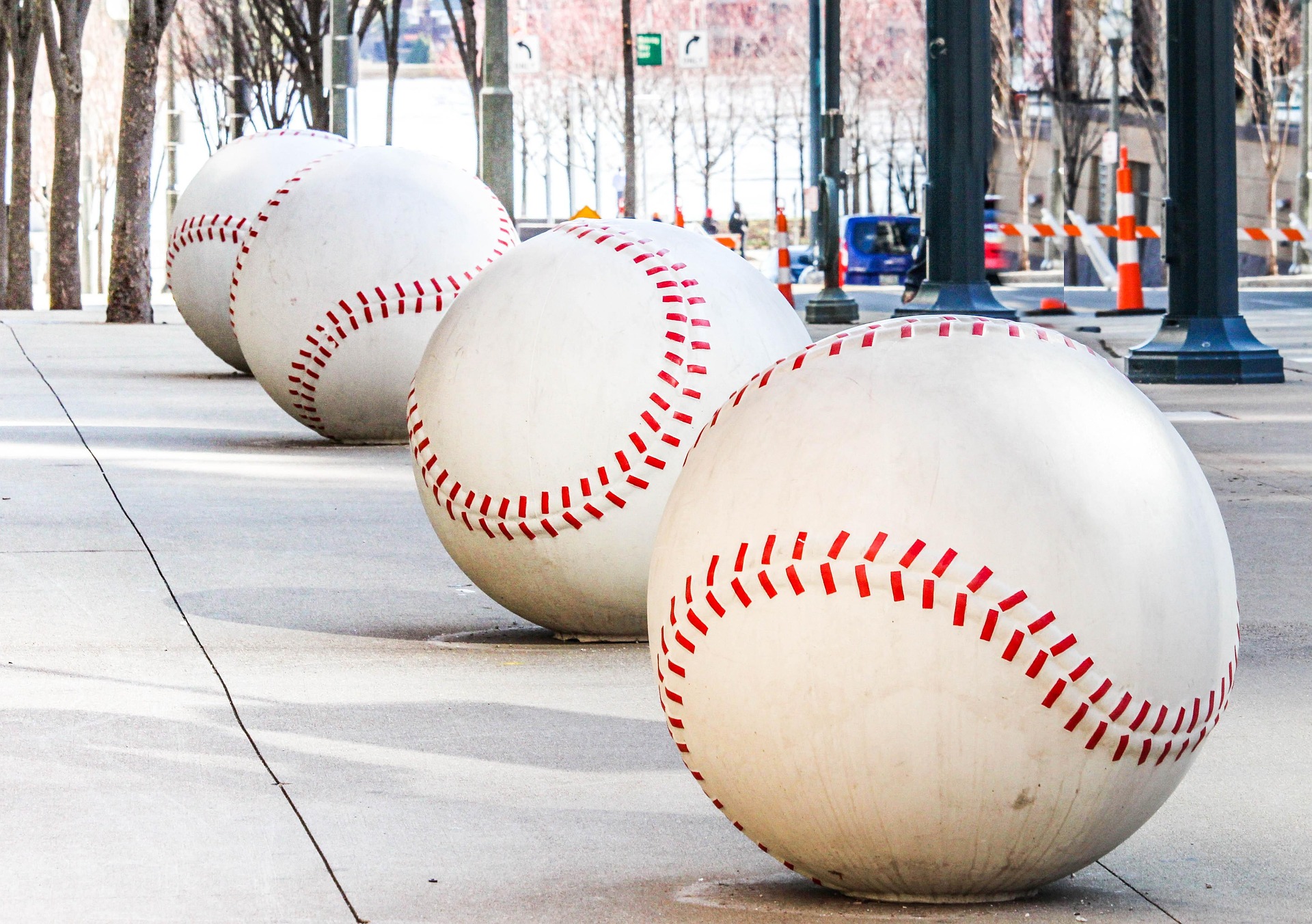 A row of oversized baseballs lines a sidewalk.
