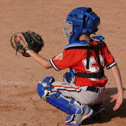 A crouching catcher raises his mitt.