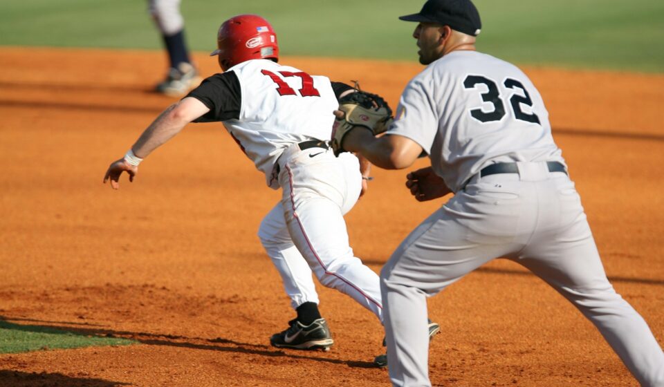 A runner races to the base while the infielder waits for the ball.