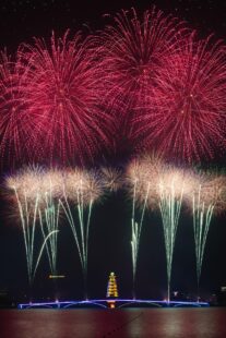 Red and white fireworks explode in the sky.
