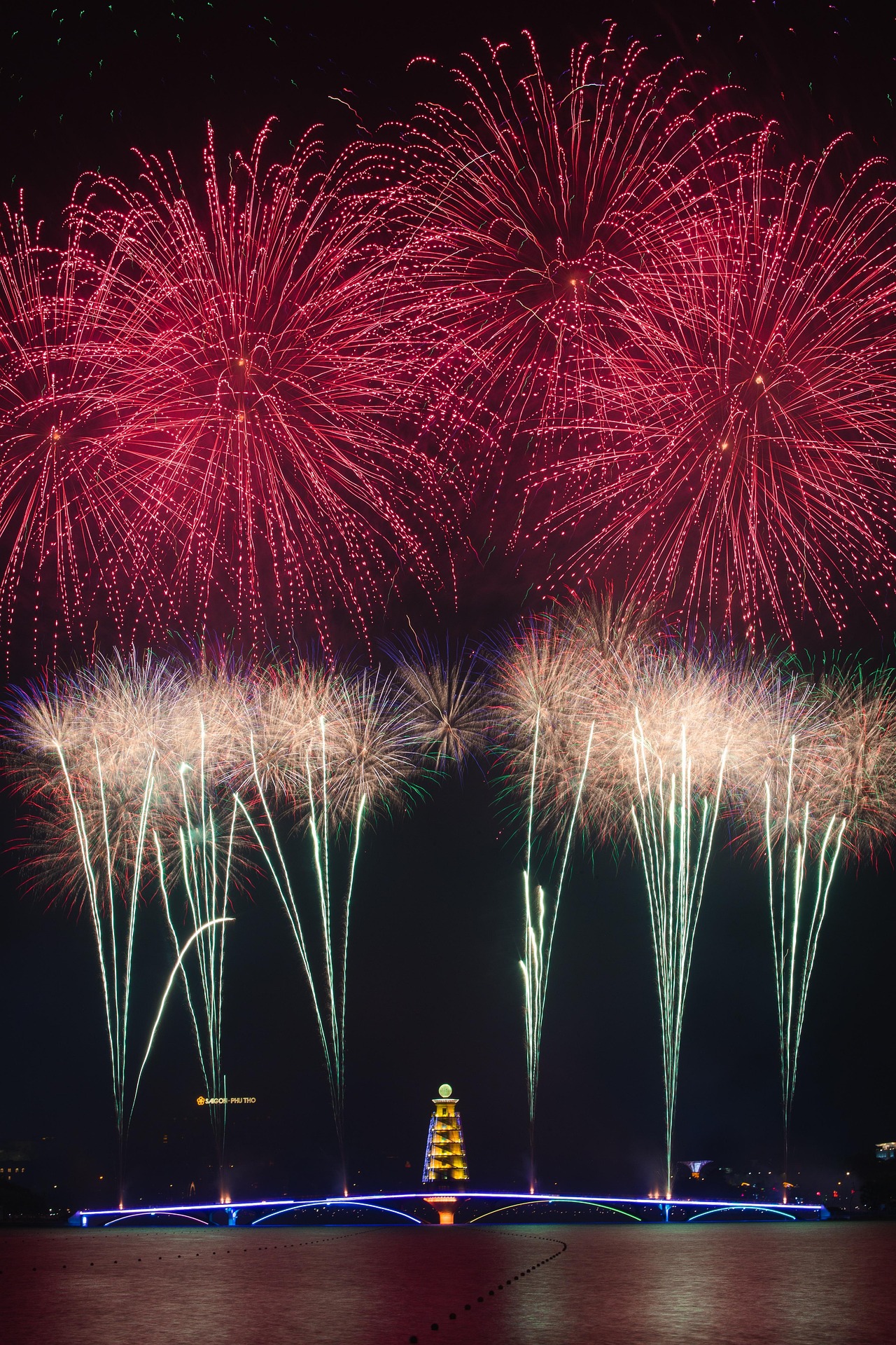 Red and white fireworks explode in the sky.