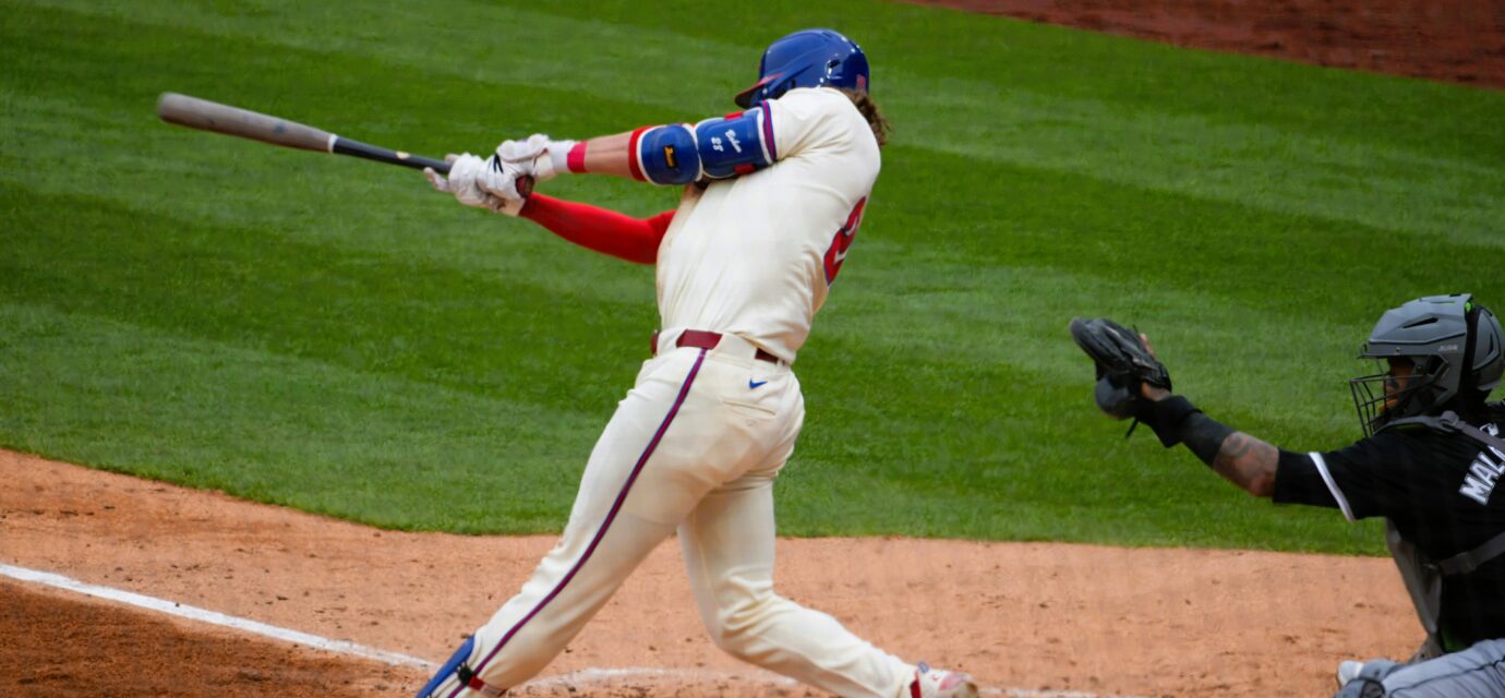 A batter swings for the ball at home plate.