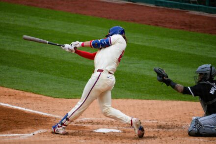 A batter swings for the ball at home plate.