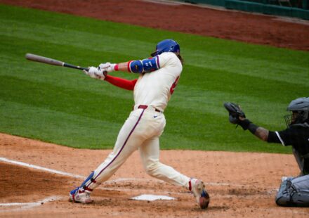 A batter swings for the ball at home plate.