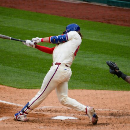 A batter swings for the ball at home plate.