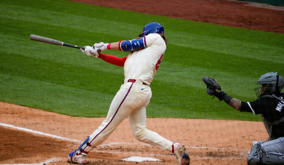 A batter swings for the ball at home plate.