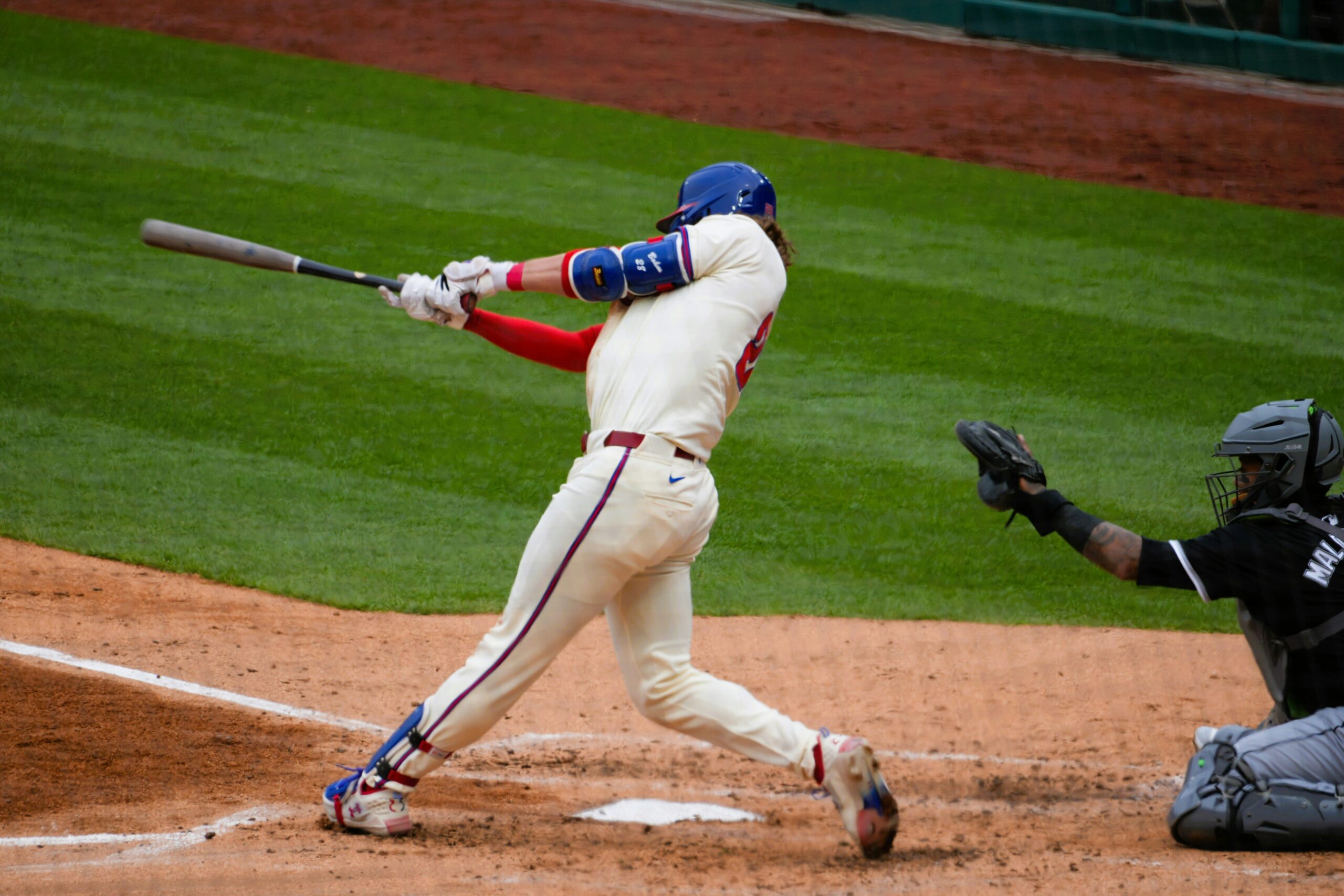 A batter swings for the ball at home plate.