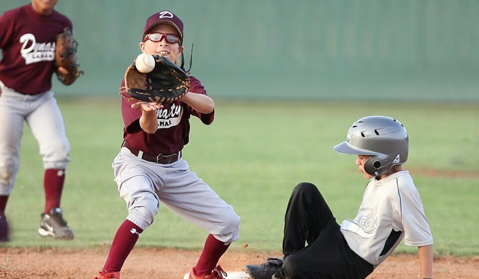 The infielder catches the ball too late, as the player sliding into base is safe.