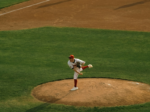 A baseball pitcher hurls the ball from the mound.
