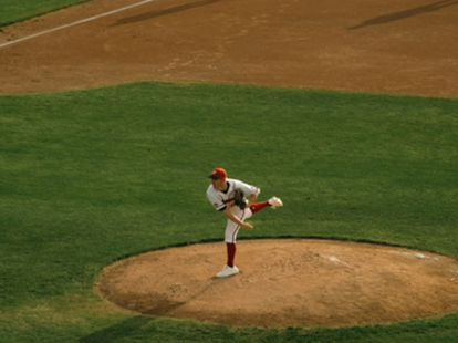 A baseball pitcher hurls the ball from the mound.