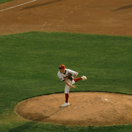 A baseball pitcher hurls the ball from the mound.
