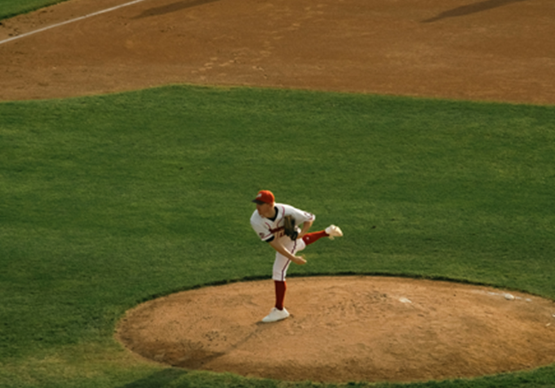 A baseball pitcher hurls the ball from the mound.