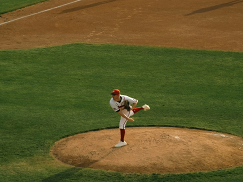A baseball pitcher hurls the ball from the mound.