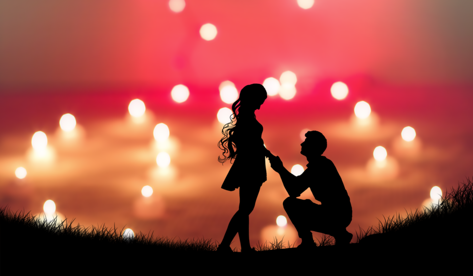 A man kneels in front of a woman with a vivid sky in the background.