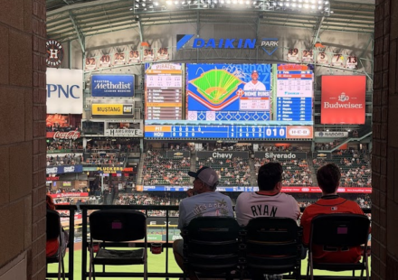 Astros fans sitting at Daikin Park, watching the big screen.