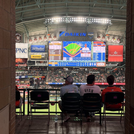 Astros fans sitting at Daikin Park, watching the big screen.