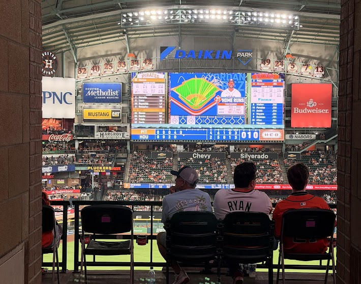 Astros fans sitting at Daikin Park, watching the big screen.